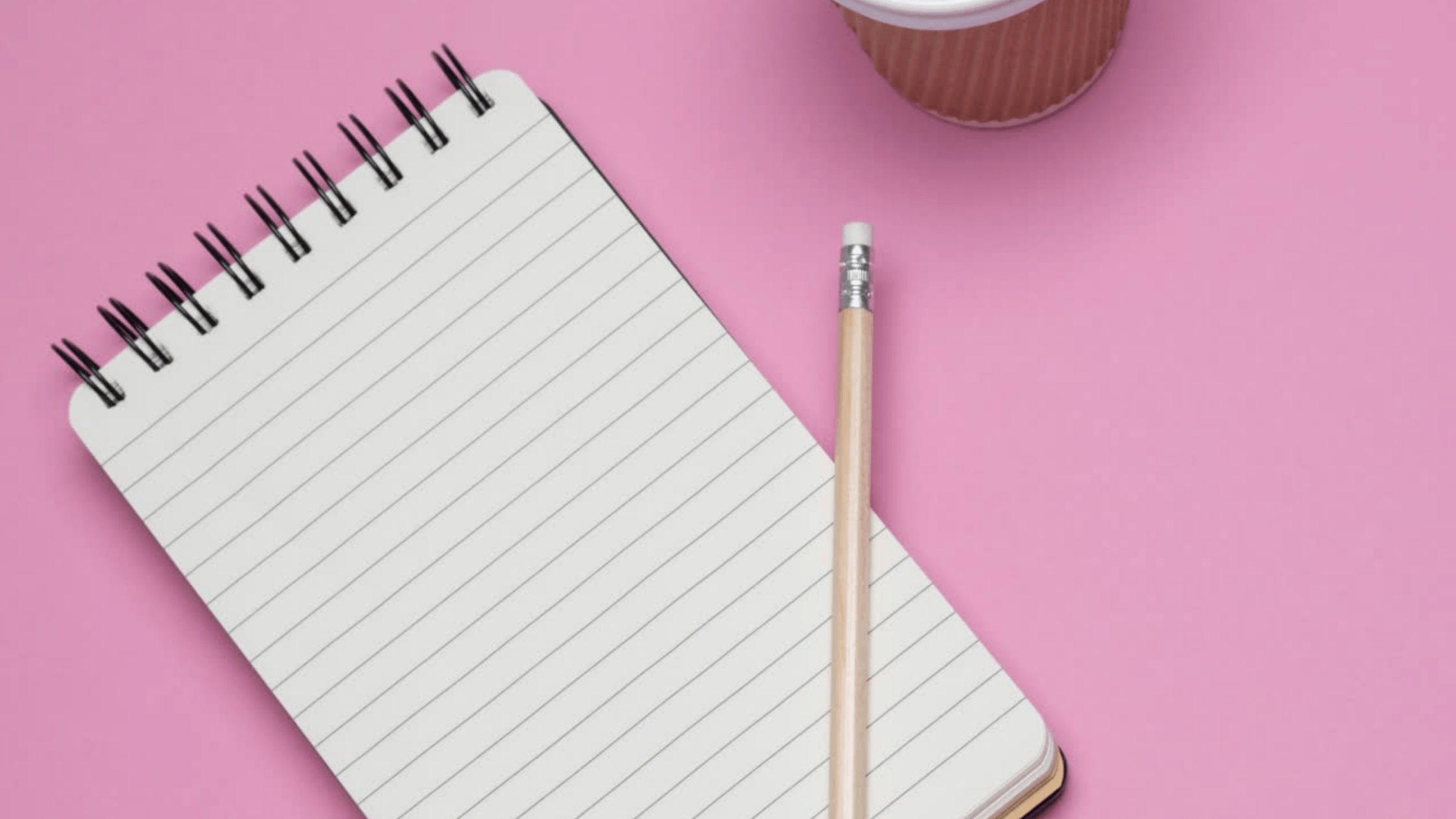 Picture of a lined notebook, pencil and take away coffee cup